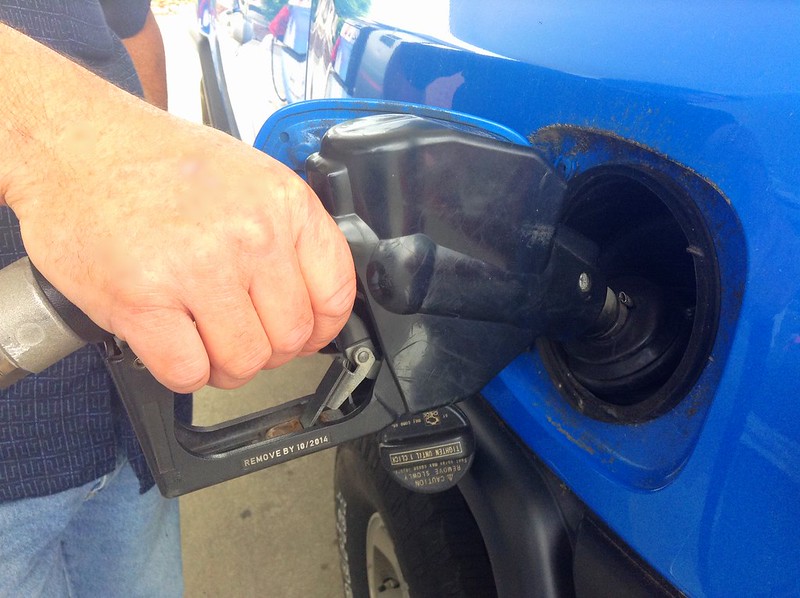 Someone pumping gasoline into vehicle