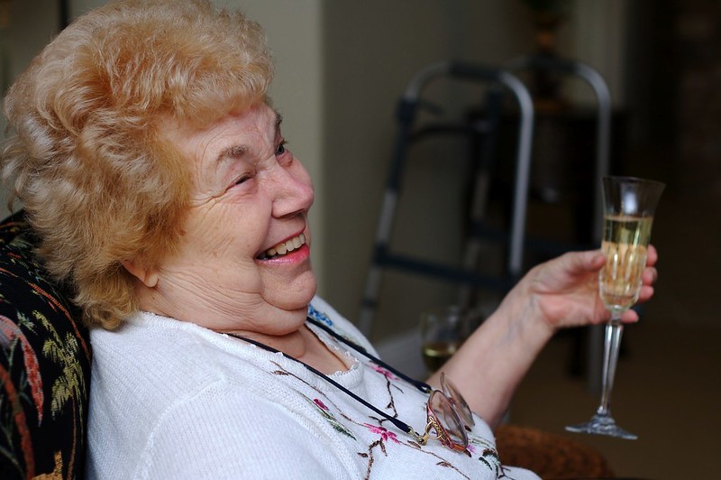 Elderly woman drinking champagne