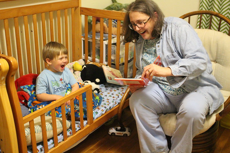 Grandmother and grandchild laughing at a book together