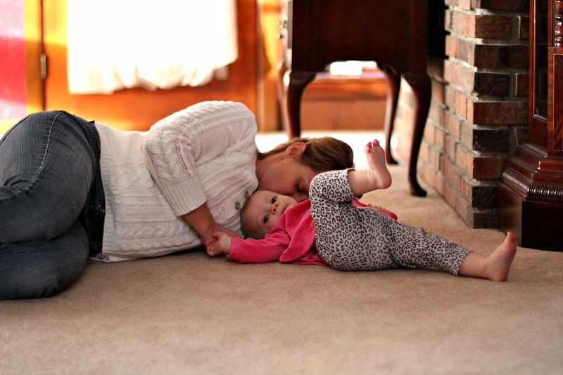 Woman and child snuggling on the floor