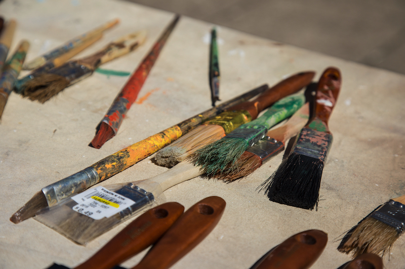 Brushes, stirrers and paint cans sit ready for use at a mural painting at Perkins Elementary School.